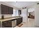 Well-lit kitchen with stainless steel appliances, granite countertops, dark wood cabinets, and tile flooring at 4615 W Del Rio St, Chandler, AZ 85226