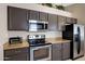 Updated kitchen boasts stainless steel appliances, dark wood cabinets, and stylish granite countertops at 4615 W Del Rio St, Chandler, AZ 85226