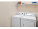 Functional laundry room with white washer and dryer, shelving and ample lighting at 4615 W Del Rio St, Chandler, AZ 85226