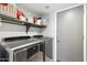 Well-equipped laundry room with modern washer and dryer, storage shelves, and convenient access to utilities at 4626 E Summerhaven Dr, Phoenix, AZ 85044