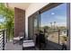 Relaxing balcony with patio chairs, exterior brick wall, and sliding glass door to the interior at 475 N 9Th St # 206, Phoenix, AZ 85006