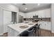 Modern kitchen with quartz island, stainless appliances, white cabinets, gray backsplash and wood floors at 475 N 9Th St # 206, Phoenix, AZ 85006
