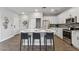 Modern kitchen features white cabinets, stainless appliances, quartz countertops, an island, and seating at 475 N 9Th St # 206, Phoenix, AZ 85006