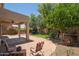 Spacious backyard featuring a covered patio, paved brick area, and well-maintained landscaping at 5208 W Straight Arrow Ln, Phoenix, AZ 85083