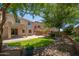 Backyard with a covered patio, brick-paved patio, a fire pit and lush green grass at 5208 W Straight Arrow Ln, Phoenix, AZ 85083