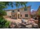 Backyard featuring a covered patio, brick-paved seating area, and vibrant landscaping with a lush lawn at 5208 W Straight Arrow Ln, Phoenix, AZ 85083
