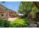 Landscaped backyard boasting a manicured lawn, brick patio, a fire pit and string lights overhead at 5208 W Straight Arrow Ln, Phoenix, AZ 85083