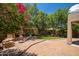 Beautiful backyard with brick patio, fireplace and green area with mature trees, perfect for relaxation at 5208 W Straight Arrow Ln, Phoenix, AZ 85083