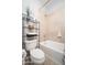 Bathroom showcasing a bathtub, toilet, and a shelf with stylish decor and organized towels at 5208 W Straight Arrow Ln, Phoenix, AZ 85083
