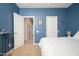 Bedroom with blue painted walls, carpeted floors, and a walk-in closet with white doors at 5208 W Straight Arrow Ln, Phoenix, AZ 85083
