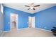 Bedroom featuring neutral carpeting, blue accent wall, and multiple doorways at 5208 W Straight Arrow Ln, Phoenix, AZ 85083