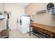 Functional laundry room complete with a washer, dryer, storage, and a wooden folding table at 5208 W Straight Arrow Ln, Phoenix, AZ 85083