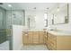 Stylish bathroom showcasing double vanities, brass fixtures, decorative floor tiles, and a glass shower enclosure at 5937 E Corrine Dr, Scottsdale, AZ 85254