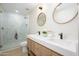 Bright bathroom with a double sink vanity, modern fixtures, and a glass-enclosed shower at 5937 E Corrine Dr, Scottsdale, AZ 85254