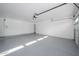 Clean, bright garage featuring a white interior, gray epoxy flooring, and an automatic garage door opener at 5937 E Corrine Dr, Scottsdale, AZ 85254