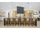 A spacious kitchen island with barstool seating, a matte black hood, and modern cabinetry at 5937 E Corrine Dr, Scottsdale, AZ 85254