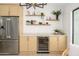Kitchen with stainless steel refrigerator, wine cooler, wooden cabinets, and decorative shelving at 5937 E Corrine Dr, Scottsdale, AZ 85254