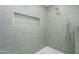 Modern walk-in shower with sleek green tiling, a niche, and gold fixtures at 5937 E Corrine Dr, Scottsdale, AZ 85254