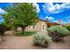 Well maintained backyard with desert landscaping, mature trees, and covered patio area at 6420 W Beverly Ln, Glendale, AZ 85306