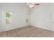 Bright bedroom with a ceiling fan, neutral carpet, white walls, and shuttered windows at 6420 W Beverly Ln, Glendale, AZ 85306