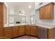 Kitchen showcasing wooden cabinetry, stainless steel appliances, and an adjacent living area with a fireplace at 6420 W Beverly Ln, Glendale, AZ 85306