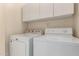 Functional laundry room with modern washer, dryer, and ample overhead cabinet storage at 6420 W Beverly Ln, Glendale, AZ 85306