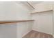 Spacious walk-in closet featuring wooden racks and neutral carpeting, maximizing storage at 6420 W Beverly Ln, Glendale, AZ 85306