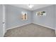 This bedroom has a ceiling fan and two windows with gray walls and gray carpet at 6808 N 11Th St, Phoenix, AZ 85014