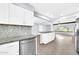 Bright kitchen with white cabinets, mosaic backsplash, stainless appliances and a kitchen island at 6808 N 11Th St, Phoenix, AZ 85014