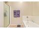 Bright bathroom featuring a shower with glass door, white tub, and towel rack at 7031 S 32Nd Pl, Phoenix, AZ 85042