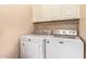 Laundry room features white appliances, overhead cabinets, and neutral walls at 7031 S 32Nd Pl, Phoenix, AZ 85042