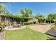 Inviting backyard with a cozy fire pit, lush landscaping, and a sparkling pool, perfect for outdoor gatherings at 7242 W Rowel Rd, Peoria, AZ 85383