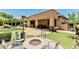 Backyard with a built-in fire pit, outdoor kitchen and manicured landscaping at 7242 W Rowel Rd, Peoria, AZ 85383