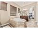 Bathroom with a soaking tub, vanity with a granite countertop, and wood-look tile flooring at 7242 W Rowel Rd, Peoria, AZ 85383