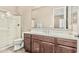 Bathroom with wood cabinets, white countertops, glass shower, and large mirror at 7242 W Rowel Rd, Peoria, AZ 85383