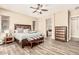 Bedroom with wood floors, ceiling fan, and ensuite bathroom at 7242 W Rowel Rd, Peoria, AZ 85383