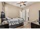 Bedroom with wood floors, ceiling fan and dark metal bed frame with bedside table at 7242 W Rowel Rd, Peoria, AZ 85383