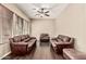 Living room with dark wood floors, tan walls, and three oversized leather sofas and ottoman at 7242 W Rowel Rd, Peoria, AZ 85383