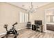 Office space featuring a chandelier, exercise bike, desk, and wood-look tile flooring at 7242 W Rowel Rd, Peoria, AZ 85383