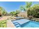 Stunning pool and spa combo featuring stone accents and mature trees, creating a relaxing backyard escape at 7242 W Rowel Rd, Peoria, AZ 85383