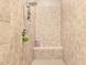 Walk-in shower featuring beige tiling throughout, a built-in bench, and recessed shelving at 7242 W Rowel Rd, Peoria, AZ 85383