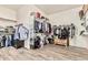 Spacious walk-in closet with custom shelving and organization, featuring wood-look tile flooring at 7242 W Rowel Rd, Peoria, AZ 85383