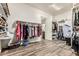 Large walk-in closet featuring custom shelving and wood-look tile flooring at 7242 W Rowel Rd, Peoria, AZ 85383