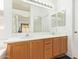 Well-lit bathroom with double sinks, wood cabinets, a large mirror, and a separate shower area at 764 E Shannon St, Chandler, AZ 85225