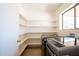 Laundry room with modern washer and dryer, built-in shelving, and a bright window at 8055 W Sanna St, Peoria, AZ 85345