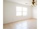 Neutral living room featuring tile floors, natural light from a bright window, and elegant ceiling fan at 8055 W Sanna St, Peoria, AZ 85345
