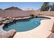 Backyard pool with rock waterfall feature, coping, and secure brick surround for privacy at 8055 W Sanna St, Peoria, AZ 85345