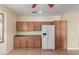 Kitchen featuring wood cabinets, white appliances, and wood laminate flooring at 8256 W Bloomfield Rd, Peoria, AZ 85381