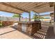 Outdoor kitchen on a covered patio featuring a stone base and built-in grill, perfect for entertaining at 8256 W Bloomfield Rd, Peoria, AZ 85381