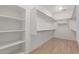 Walk-in closet featuring built-in shelves, and wood laminate flooring at 8256 W Bloomfield Rd, Peoria, AZ 85381